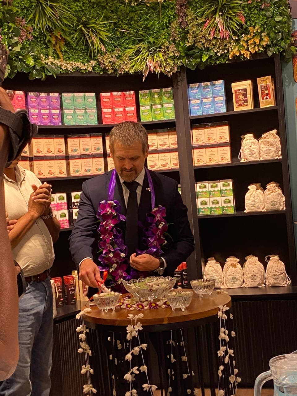 A guest wearing a flower garland beside a display inside Knuckles Valley.