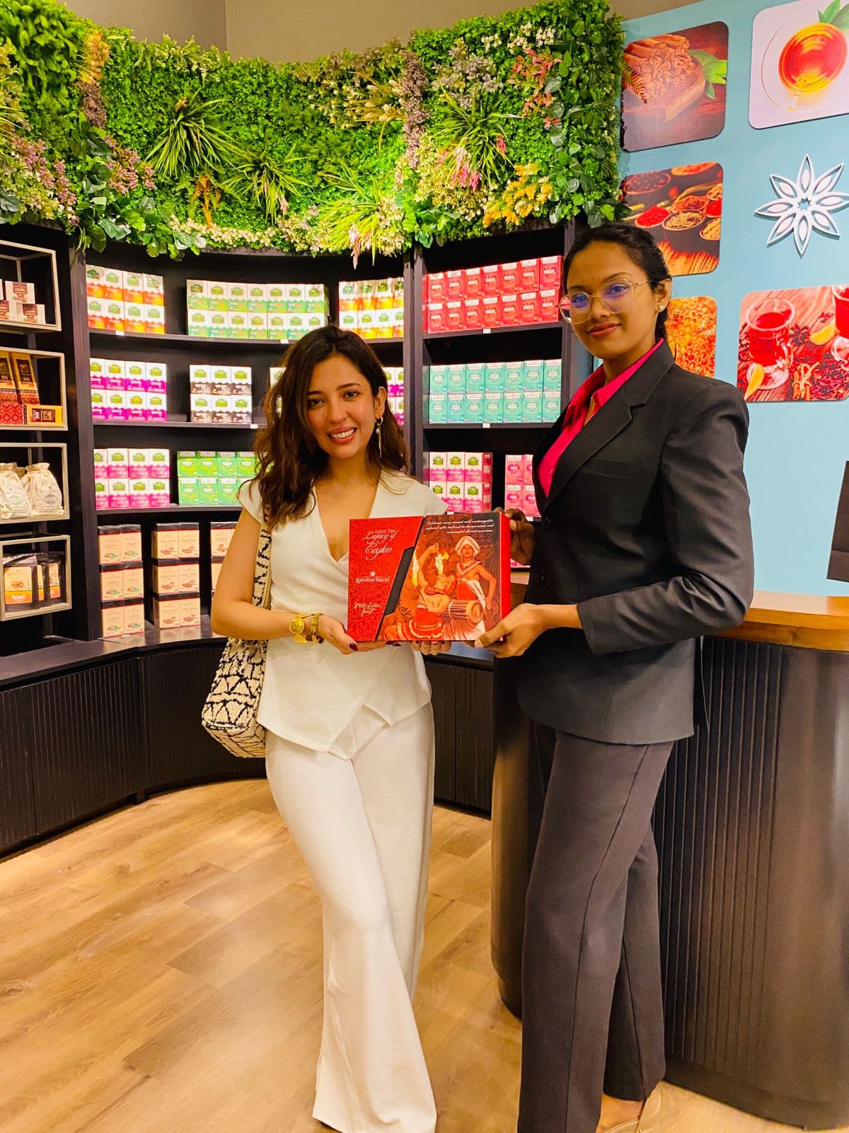 A visitor and team member hold a gift box inside the Knuckles Valley store.