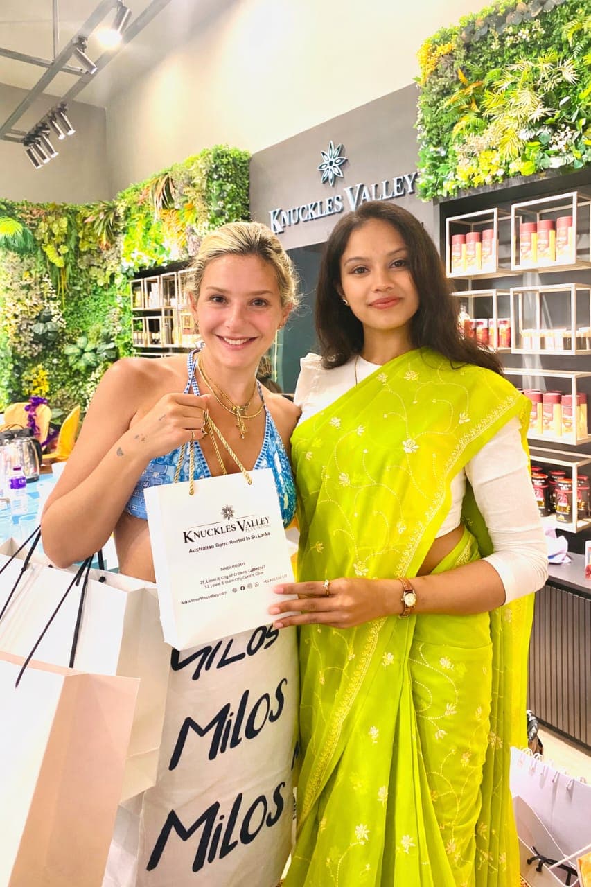 Two women pose together with bags inside the Knuckles Valley store.