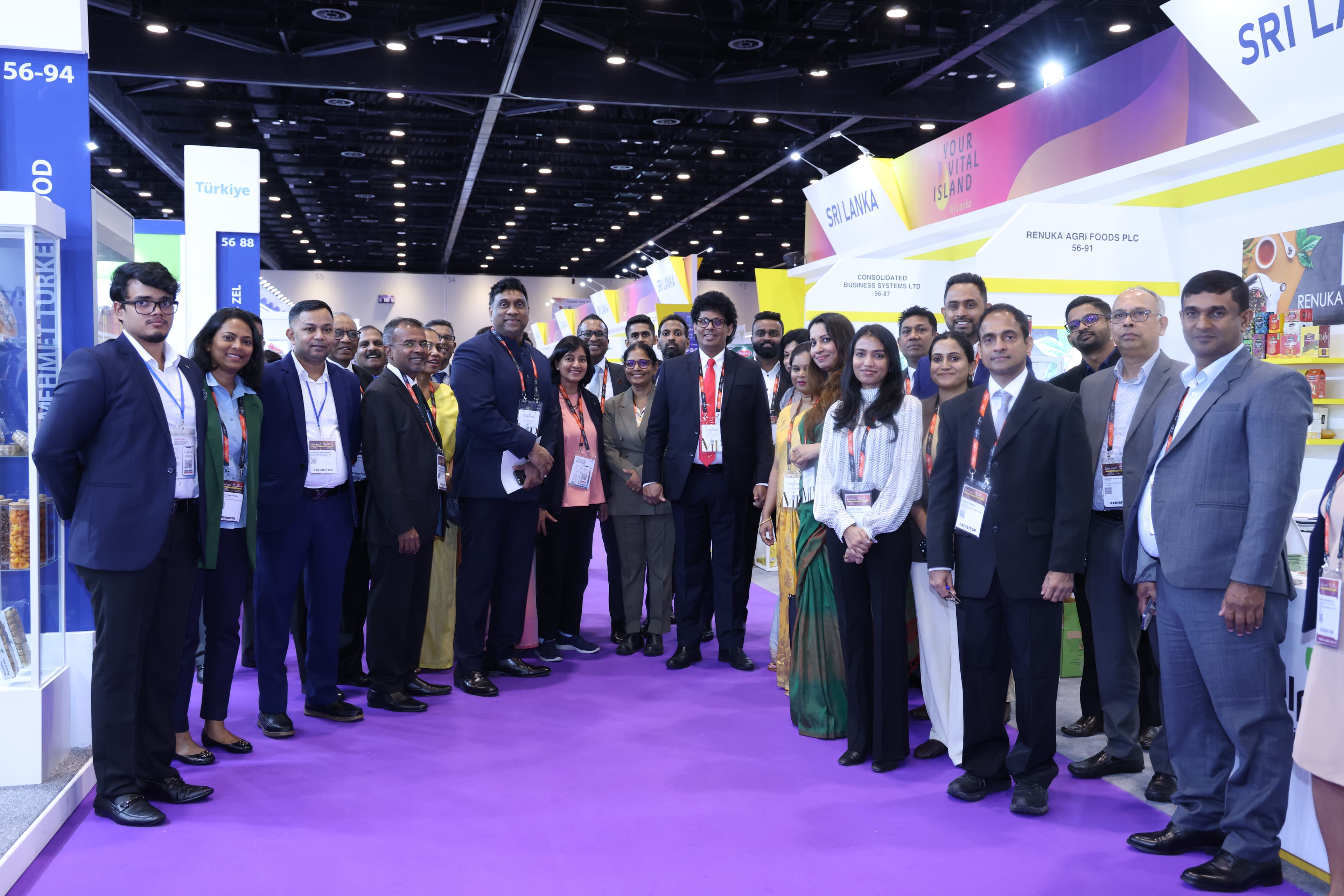 A group of exhibitors and guests gathers on the purple carpet at the Sri Lankan pavilion.