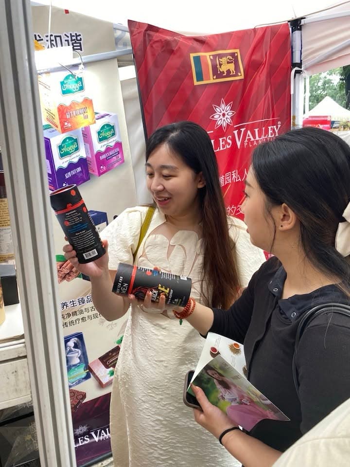 Two women examine a packaged product at the Knuckles Valley exhibition stand.