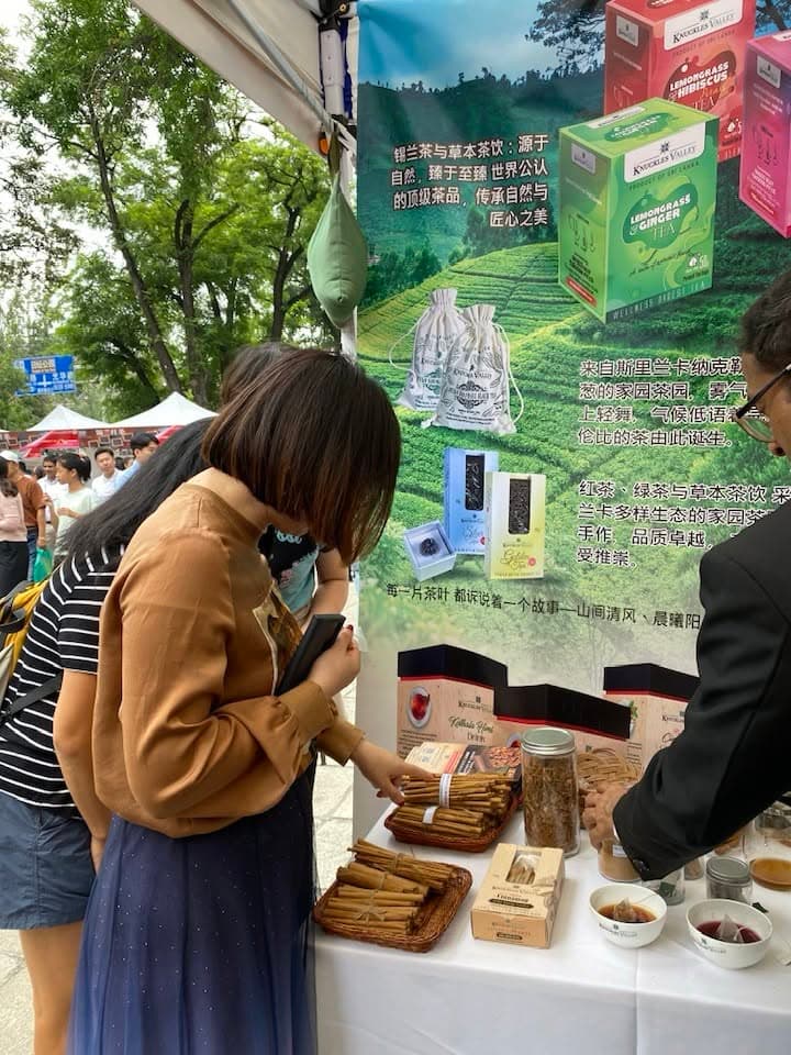 A visitor leans over the outdoor Knuckles Valley table to explore the products on display.