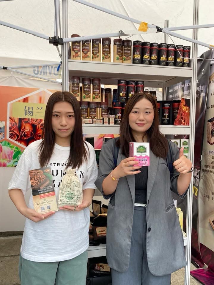 Two visitors hold packaged products at the Knuckles Valley stand in Beijing.