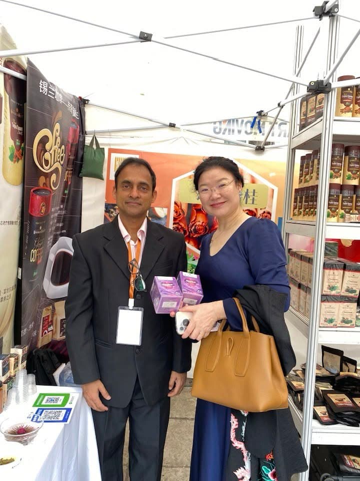Two visitors hold Knuckles Valley products together beside the exhibition display.