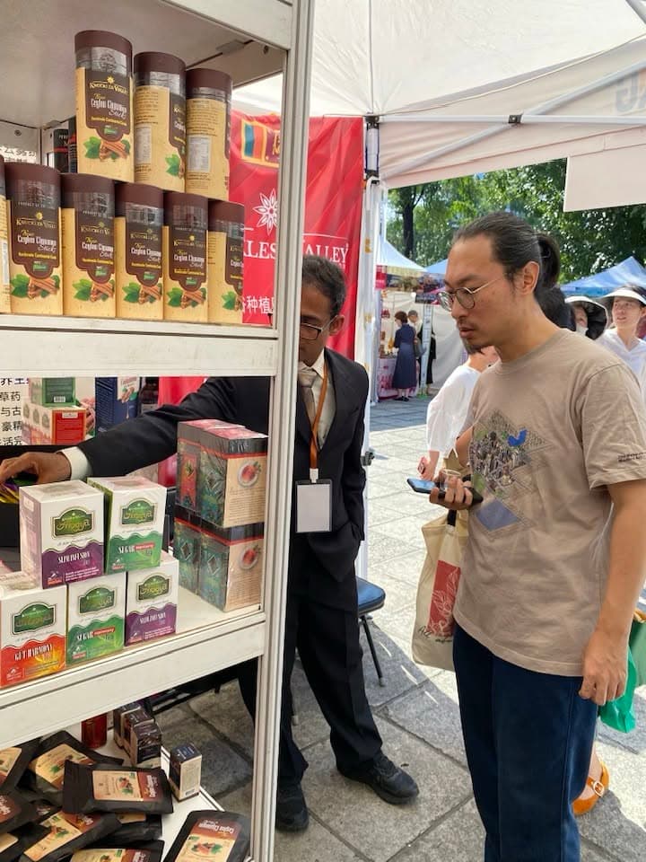 A man looks at jars on the Knuckles Valley shelves beneath an outdoor exhibition canopy.