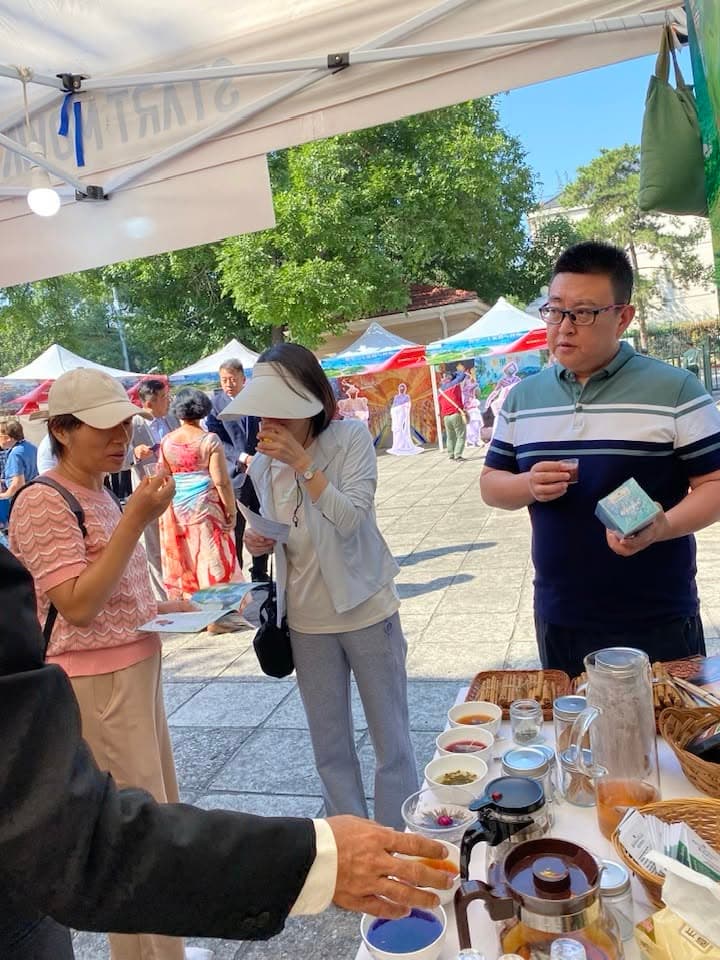 Visitors sample products beside the outdoor Knuckles Valley stand in Beijing.