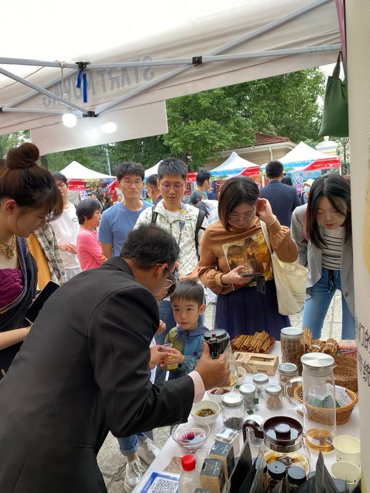 Visitors gather around the Knuckles Valley tasting table beneath an outdoor canopy.