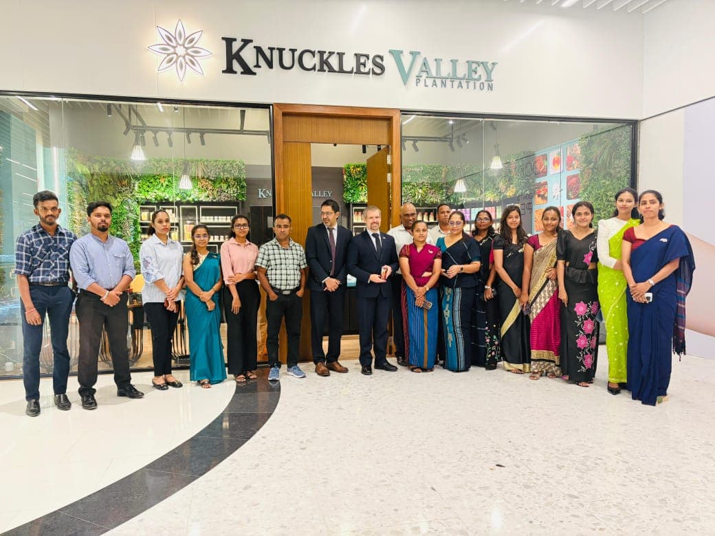 A group of guests and team members stands outside the Knuckles Valley store.
